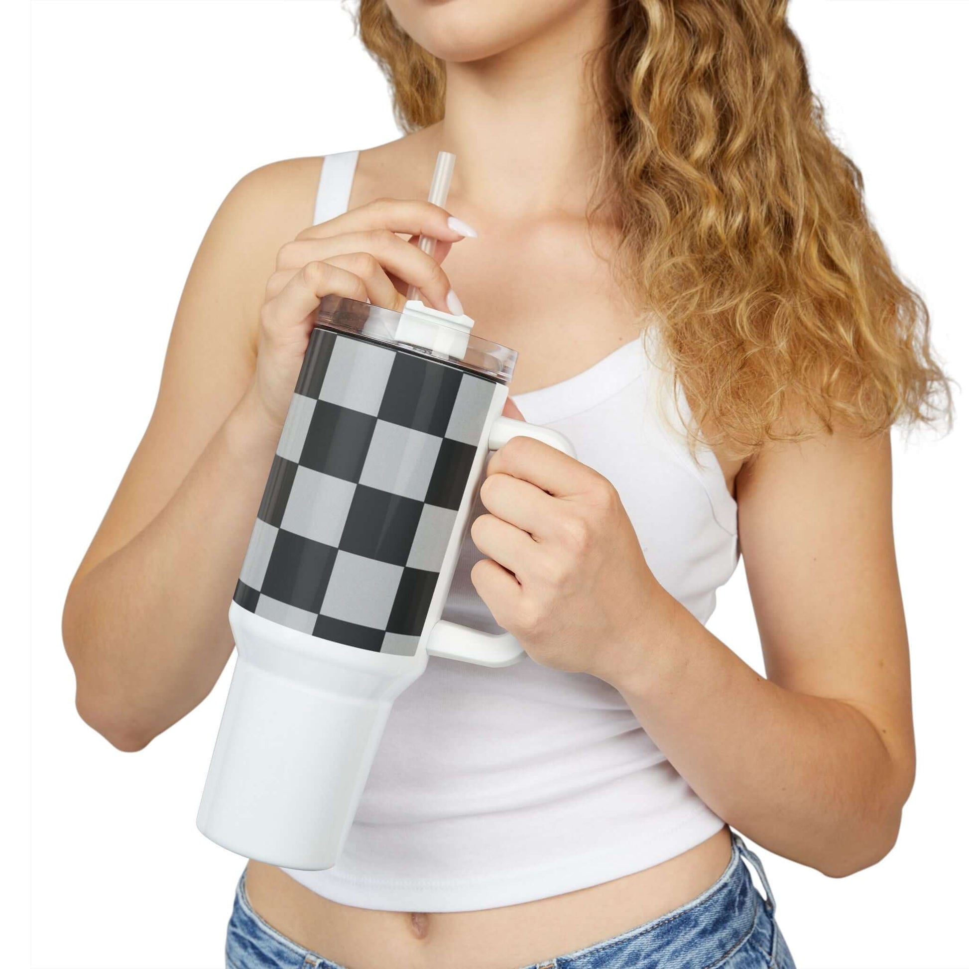 Checkered Fitness Lifestyle Tumbler held by a woman with a straw, showcasing its stylish design and functionality.